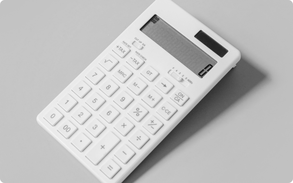 White old school calculator on grey background